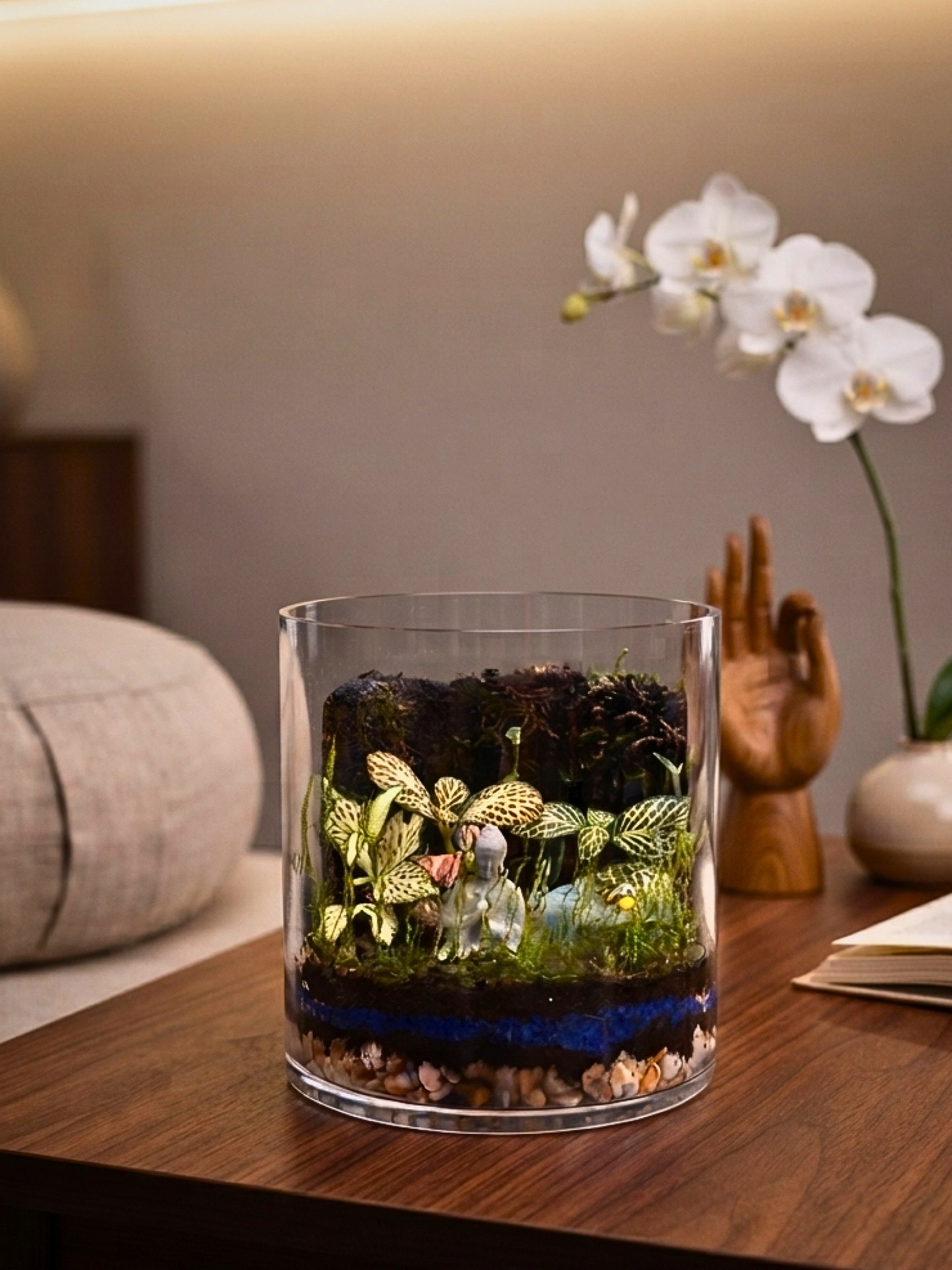 Close up of mindfulness terrarium with emerald prosperity stones, moss and tropical Fittonia plants